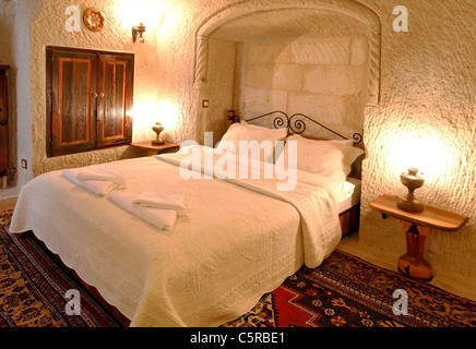 Détailler intérieur architectural de chambre avec lit orné de laiton, de draps blancs et de coussins, placard incrusté Banque D'Images