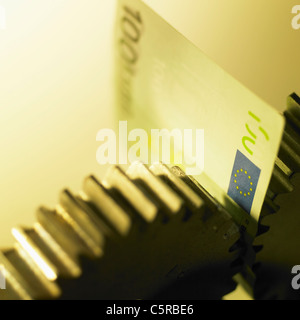 L'argent de papier entre la roue à dents de scie Banque D'Images