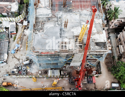 Éditorial. Vue aérienne d'une grue rouge cadre jaune de levage d'une grue en place sur un site en développement, à l'horizontale, l'espace de culture, de copie Banque D'Images