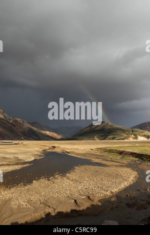 Et arc-en-ciel d'orage sur les montagnes de Rhyolite Barmur et la rivière Jokulgilskvisl Landmannalaugar Islande Banque D'Images