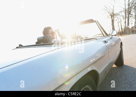 Allemagne, Hambourg, Mid adult man driving vintage car près de l'Elbe Banque D'Images