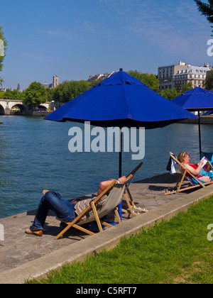 Paris, France, les gens qui apprécient l'événement annuel sur la plage de la ville, Paris Plage, Parapluie, chaises longues sur le quai, Paris d'été Banque D'Images