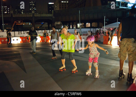 Patins à roulettes de divers niveaux de compétence, la manipulation de la nouvelle patinoire au-dessous de la Le parc High Line à New York Banque D'Images