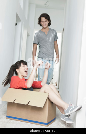 Allemagne, Cologne, jeune femme à l'intérieur de la boîte et l'homme debout à côté de la rénovation d'appartement Banque D'Images