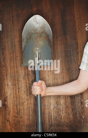 Homme tenant un chat en face de fond de bois. Banque D'Images