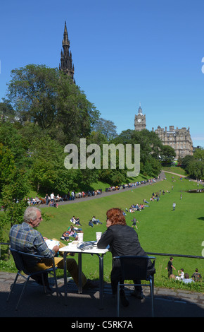 Un couple prendre un café et admirer la vue sur les jardins de Princes Street en direction du Scott Monument et de l'hôtel Balmoral. Banque D'Images