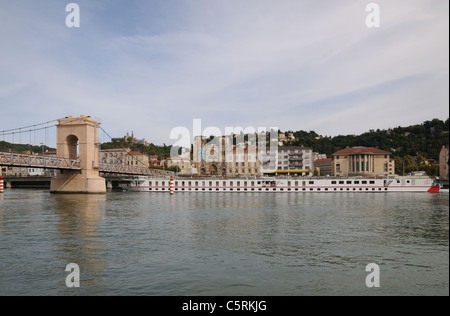 Bateau de croisière sur le Rhône en passant sous la passerelle Vienne France avec Cathédrale et Notre Dame de Pipet sur hill Banque D'Images