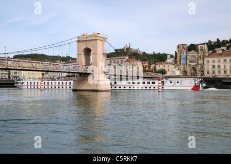 Bateau de croisière sur le Rhône en passant sous la passerelle Vienne France avec Cathédrale et Notre Dame de Pipet sur hill Banque D'Images