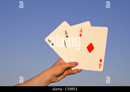 Main tenant de bonnes cartes à jouer au poker. Trois d'une sorte. As. Banque D'Images