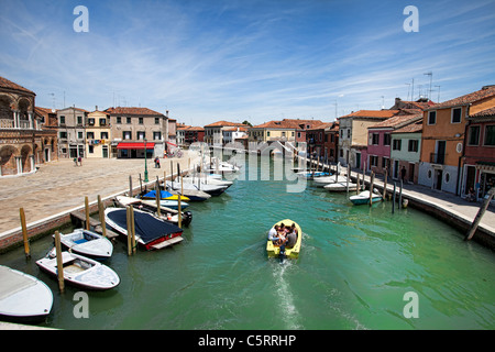 L'île de Murano's grand canal entre vieux bâtiments historiques colorés. Bateaux amarrés devant business' le long du canal. Banque D'Images