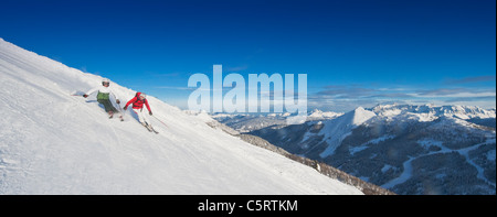 L'Autriche, Pays de Salzbourg, Altenmarkt-Zauchensee, Mid adult couple skier sur une piste de ski en hiver Banque D'Images