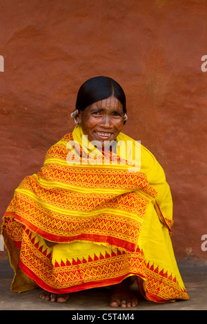 Une femme de l'Inde tribale assis dans un sari jaune vif Banque D'Images