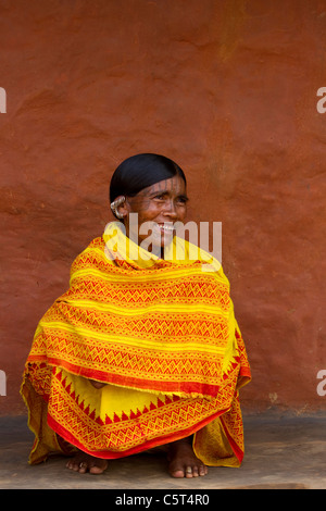 Une femme de l'Inde tribale assis dans un sari jaune vif Banque D'Images