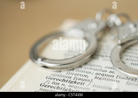 Les menottes contre dictionnaire fond coloré, Close up Banque D'Images