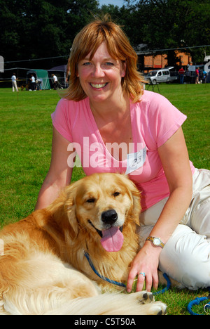 Fier propriétaire avec son compagnon à un Golden Retriever dog show, Bordon, Hampshire, Royaume-Uni. Banque D'Images