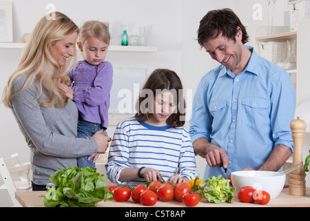 Germany, Bavaria, Munich, fils preparing salad avec père, mère et fille en plus permanent Banque D'Images