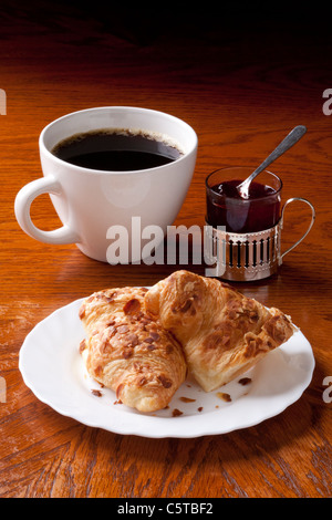 Matin petit déjeuner avec croissants, café et confiture de fraise. Banque D'Images