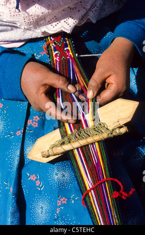 Femme indienne en vêtements traditionnels tissage d'une couverture ou d'un poncho à Cuzco Banque D'Images