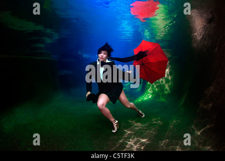 Femme tenant un parapluie sous l'eau Banque D'Images