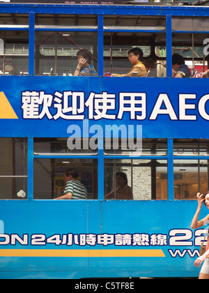 Close up vue latérale d'un tram avec passagers sur les fenêtres dans l'île de Hong Kong Banque D'Images