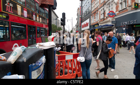 Au milieu d'acheteurs poubelles attendent le bus rouge à passer sur occupation Oxford Street près de la route à la station de métro de Bond St. à Londres UK KATHY DEWITT Banque D'Images