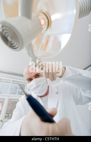 Germany, Bavaria, Landsberg, dentiste wearing mask holding équipement médical, Banque D'Images