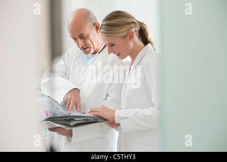 Germany, Bavaria, Landsberg, dentiste et femme dentiste assistant portant documents, portrait Banque D'Images