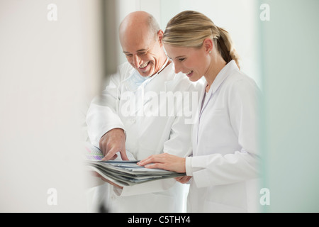 Germany, Bavaria, Landsberg, dentiste et femme dentiste assistant portant documents, portrait Banque D'Images