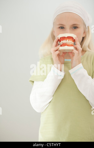 Germany, Bavaria, Landsberg, Girl (8-9) holding model de dents Banque D'Images