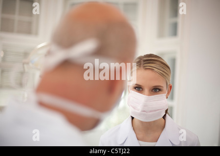 Germany, Bavaria, Landsberg, dentiste et Femmes Assistant Dentiste wearing mask Banque D'Images