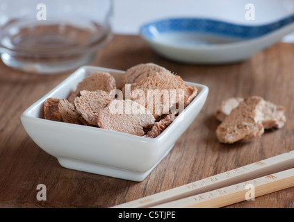 Plat de tranches de galanga séché, prêt à être utilisé pour la cuisson d'un repas Asiatique. Banque D'Images