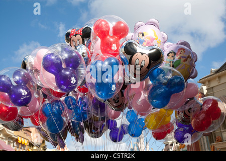 Un groupe de ballons à hélium sur le thème de Walt Disney flottant ensemble attachés par une ficelle avec le visage de Mickey Mouse bien en évidence Banque D'Images