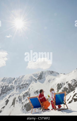 L'Autriche, Salzburger Land, jeune couple assis dans une chaise, holding glasses Banque D'Images