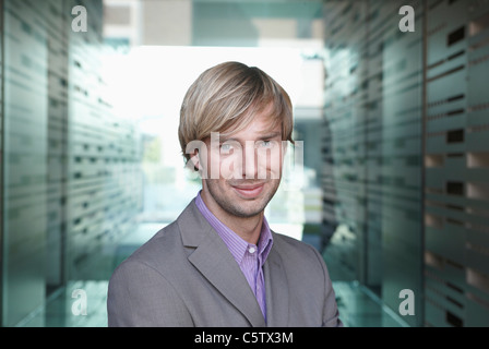 Allemagne, Cologne, businessman standing in corridor, portrait Banque D'Images