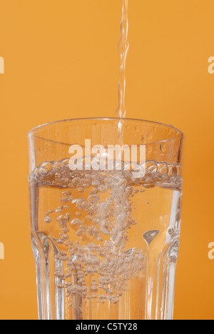 L'eau est versée dans le verre, Close up Banque D'Images