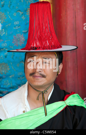 Dans un temple bouddhiste villager attend d'exécuter au shaman Harvest Festival, Tongren, de la province de Qinghai, Chine Banque D'Images