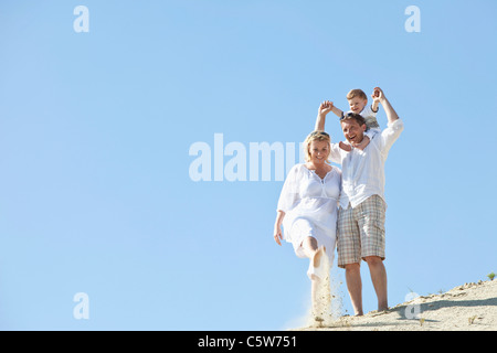 Allemagne, Family walking on sand dune Banque D'Images