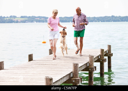 Germany, Berlin, Young man with Golden Retriever on jetty Banque D'Images
