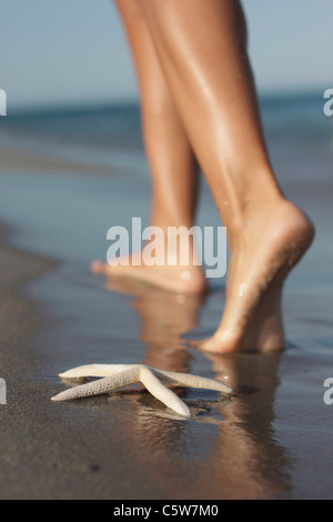 Italie, Sardaigne, Woman's feet walking on beach Banque D'Images