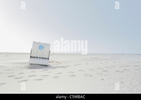 Allemagne, Schleswig-Holstein, Amrum, chaise de plage en osier couvert on beach Banque D'Images