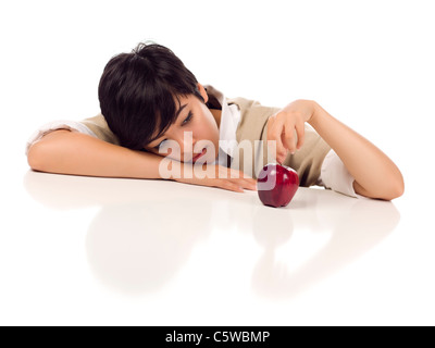 Mélancolie Mixed Race jeune femelle adultes assis à table avec Apple blanc isolé sur fond blanc - l'accent est sur Apple Banque D'Images