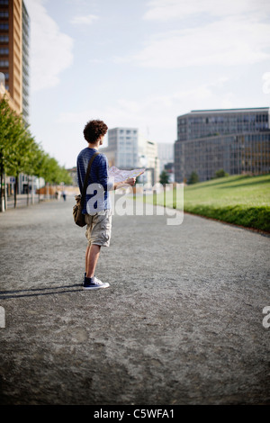 Allemagne, Berlin, Young man holding plan de ville Banque D'Images