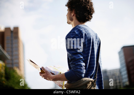 Allemagne, Berlin, Young man holding plan de ville Banque D'Images