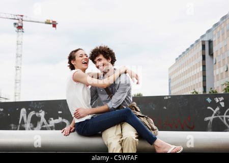 Allemagne, Berlin, Young couple in front of nouveau bâtiment, des grues en arrière-plan Banque D'Images