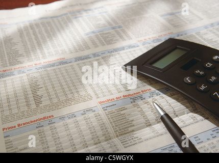 Close up de calculatrice sur un journal avec les prix des actions Banque D'Images