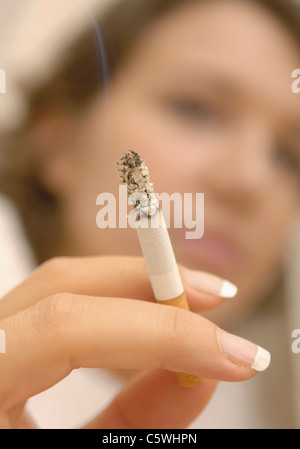 Close up of woman's finger holding cigarette brûlée Banque D'Images