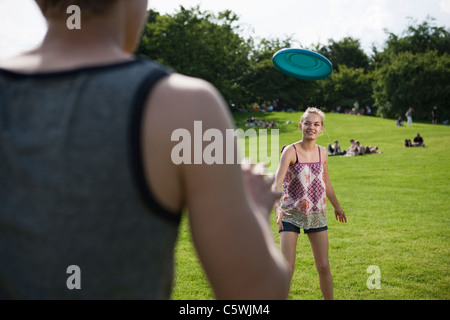 Allemagne, Berlin, Teenage girl and boy playing frisbee in park Banque D'Images