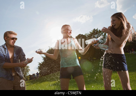 Allemagne, Berlin, teenage girls and boy playing in park Banque D'Images