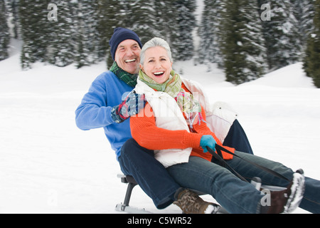 Germany, Berlin, Young couple sledding Down hill, rire, portrait Banque D'Images