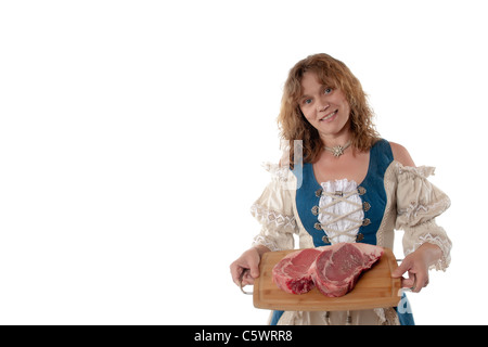 Woman in dirndl avec de la viande crue, la viande des steaks de marché Banque D'Images